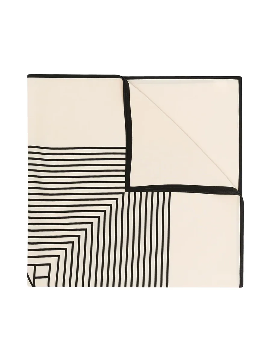 Folded corner of a cream silk scarf with black stripes and a black border