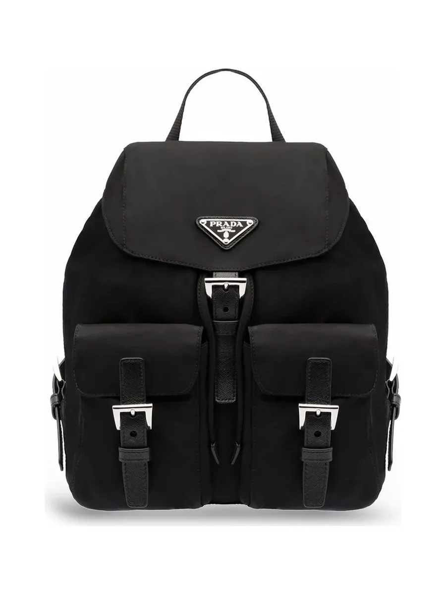 Small black nylon backpack with a triangle logo plaque on the flap and two front buckle pockets