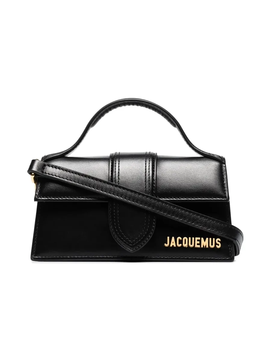 Black leather flap bag with a top handle, shoulder strap and gold-tone logo lettering, front view