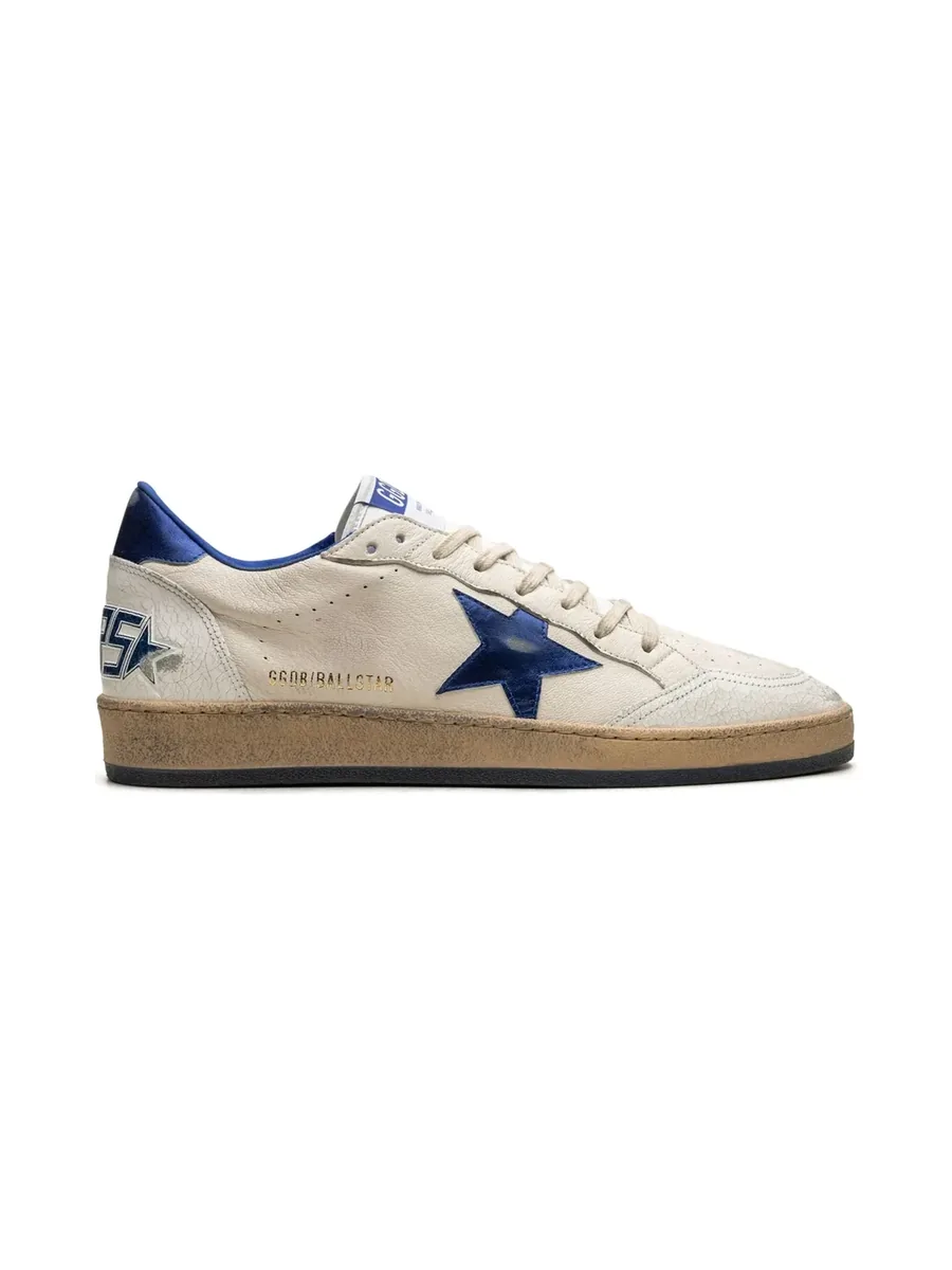 Ivory leather sneaker with a cobalt blue star and heel tab, side view