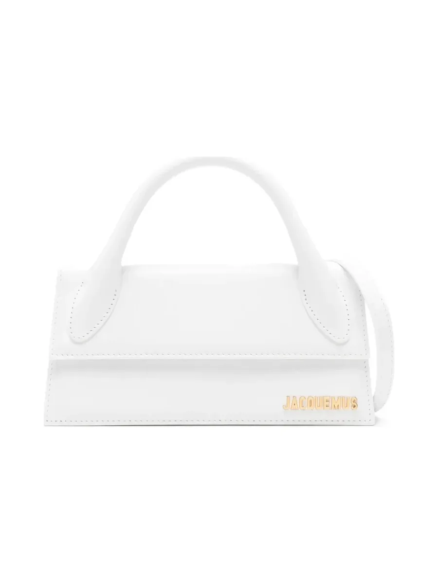 White elongated leather bag with a single top handle and gold-tone logo lettering, front view