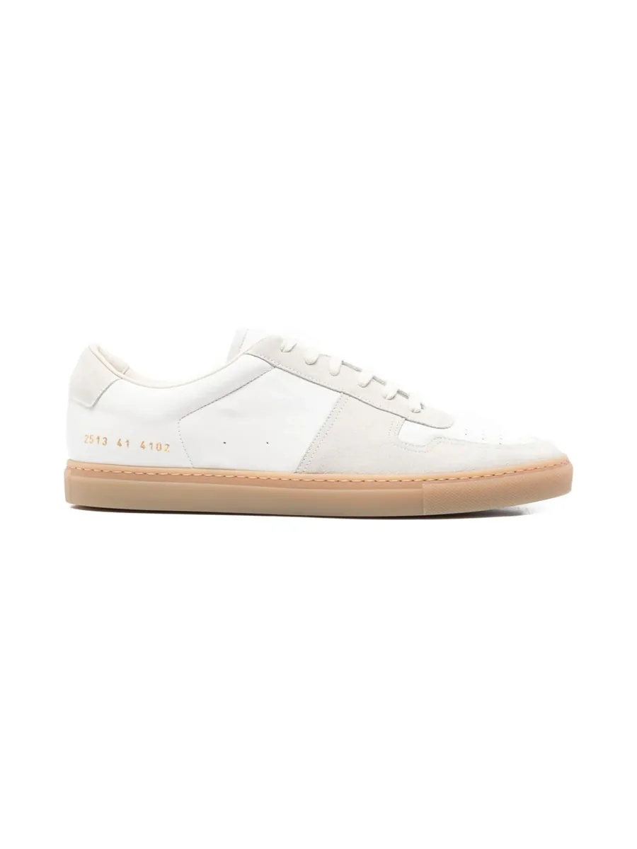 White suede and leather low-top sneaker with a tan rubber sole, side view